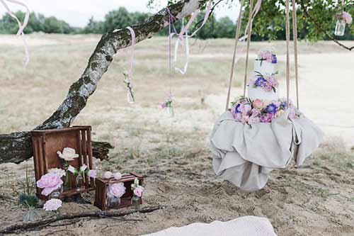 Hochzeitstorte steht auf einer Schaukel