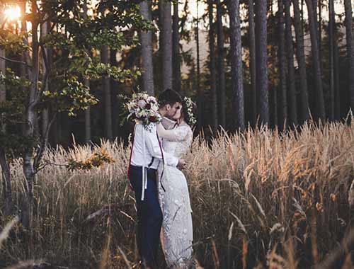 Brautpaar küsst sich im Wald
