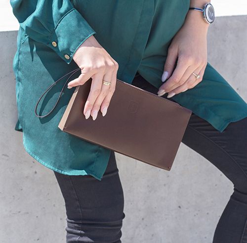 A brown-haired woman with an elegant leather clutch bag