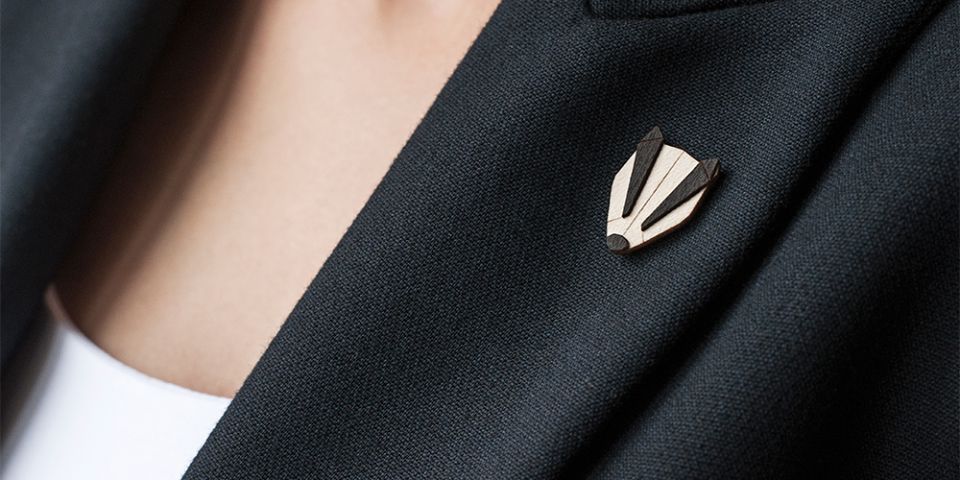 BeWooden - Eine Frau in einer Jacke mit der Holzbrosche Badger Brooch