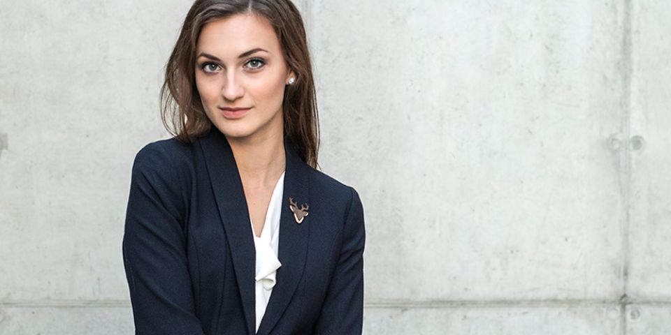 BeWooden - Eine Frau in einer Jacke mit der Holzbrosche Deer Brooch