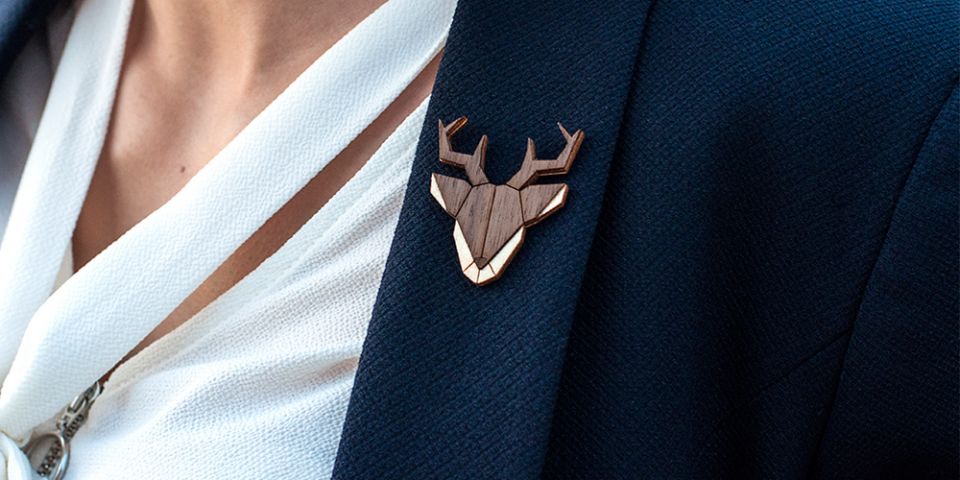 Eine Frau in einer Jacke mit der Holzbrosche Deer Brooch