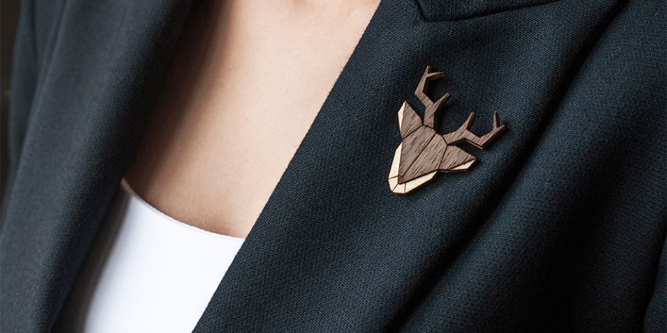 Eine Frau in einer Jacke mit der Holzbrosche Deer Brooch