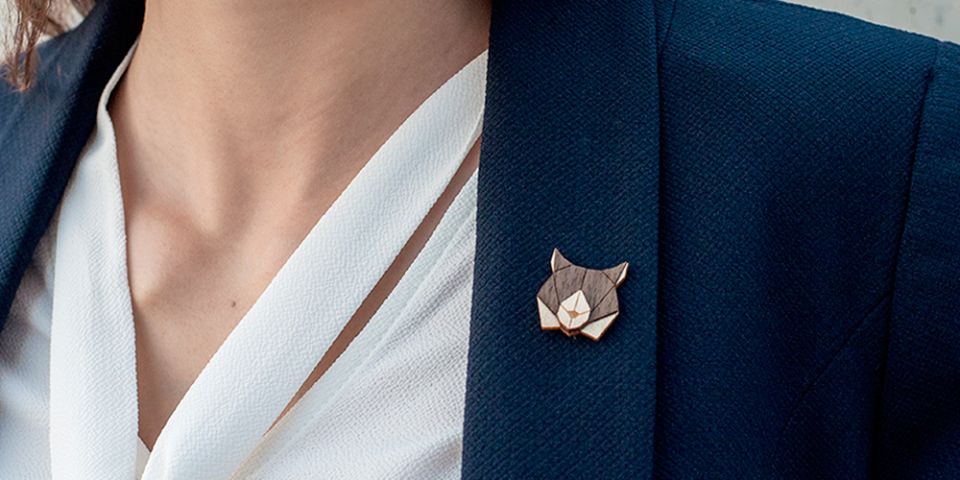 Eine Frau in einer Jacke mit der Holzbrosche Lynx Brooch