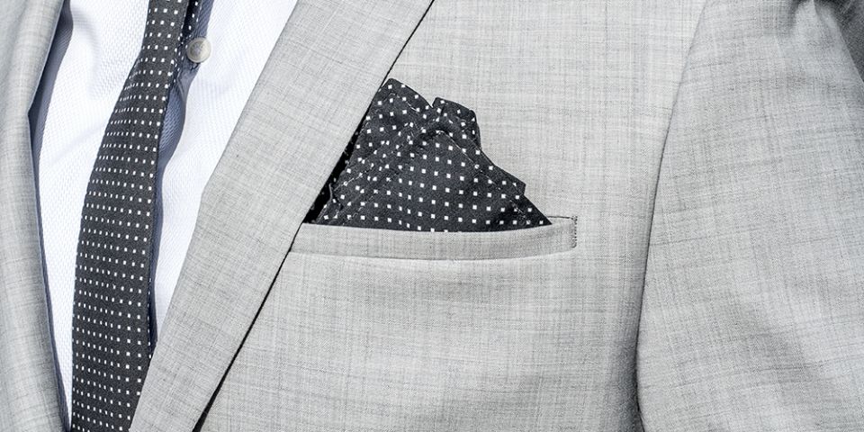 Mann in einer grauen Jacke mit Coloo square Einstecktuch und Krawatte Coloo Tie Mann in einer grauen Jacke mit Coloo square Einstecktuch und Krawatte Coloo Tie