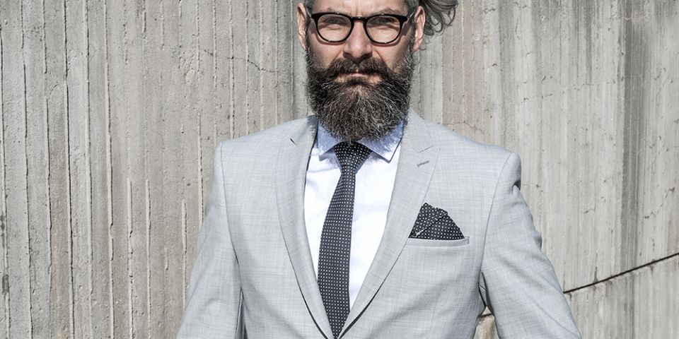 Mann in einer grauen Jacke mit Coloo square Einstecktuch und Krawatte Coloo Tie Mann in einer grauen Jacke mit Coloo square Einstecktuch und Krawatte Coloo Tie