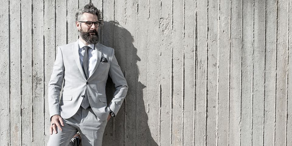 Mann in einer grauen Jacke mit Coloo square Einstecktuch und Krawatte Coloo Tie Mann in einer grauen Jacke mit Coloo square Einstecktuch und Krawatte Coloo Tie