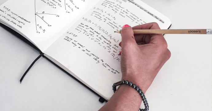 Frau mit dem Silver Hematit Armband schreibt in das Notizbuch