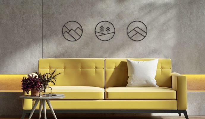 Moderne Wanddekoration mit runden Kunstwerken über einem gelben Sofa